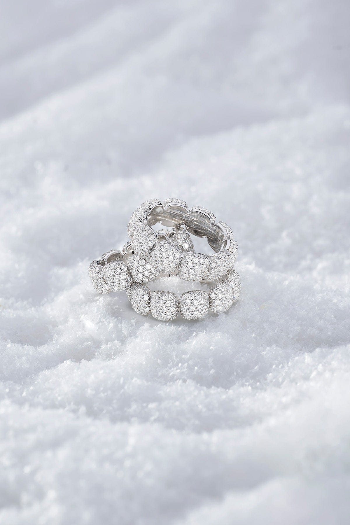 Stack of APM MONACO silver pave rings on a snowy surface