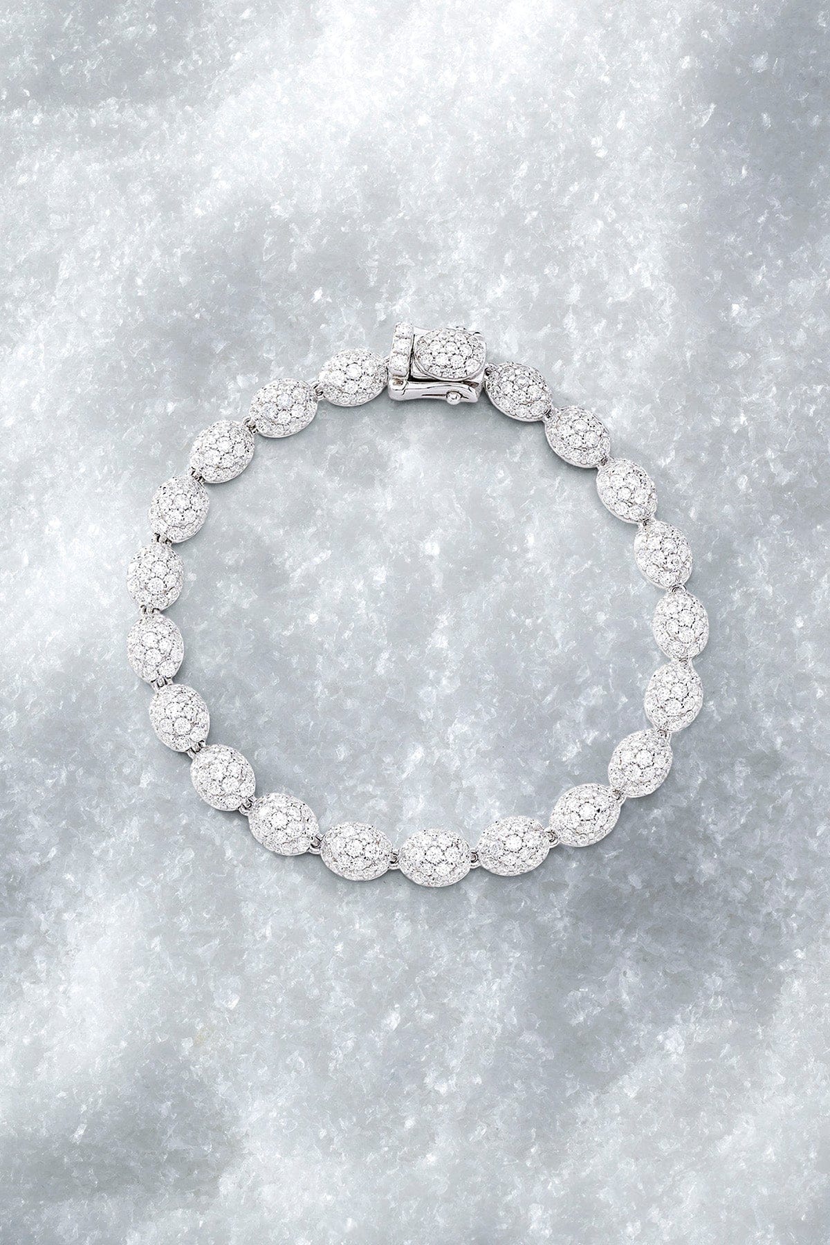 APM MONACO pave bracelet in silver with clear stones on a pure iced surface