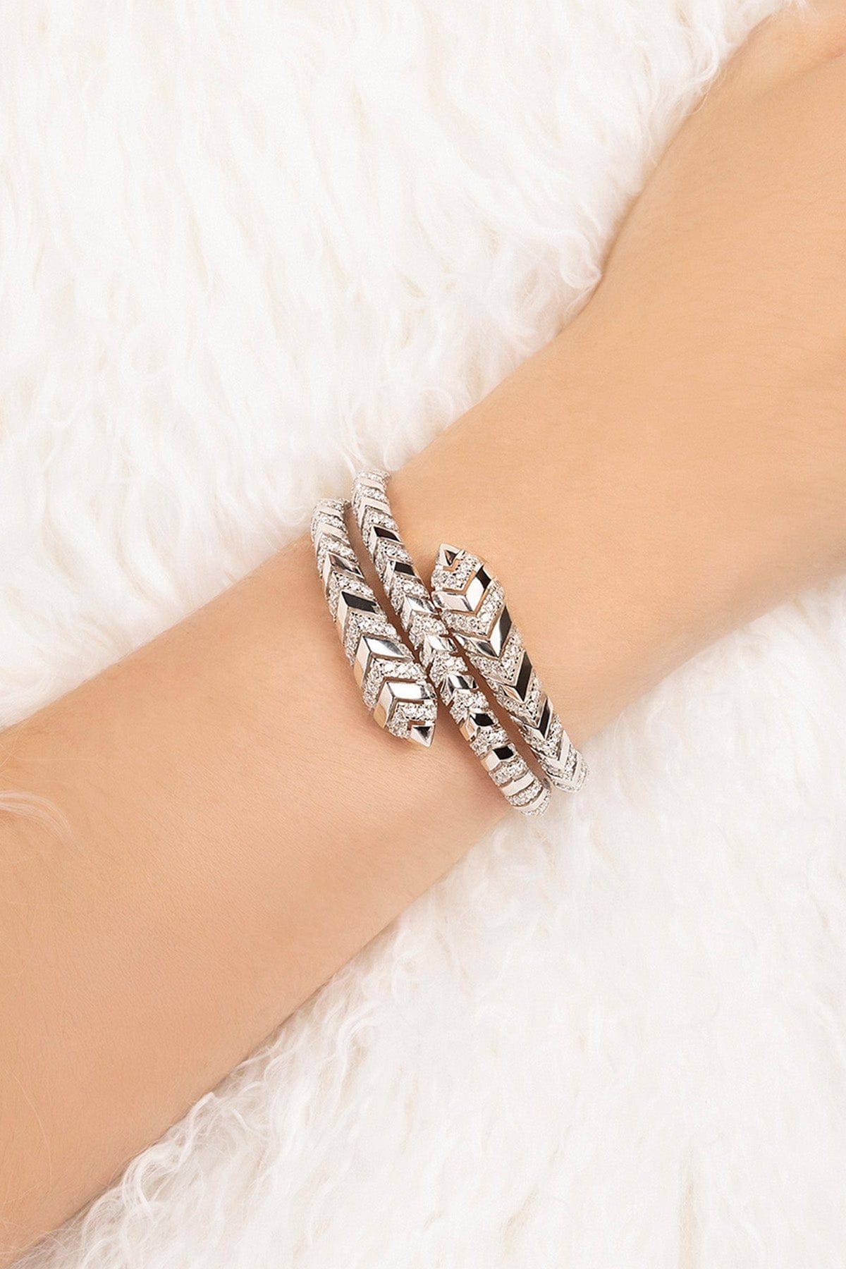 Silver bracelet on a wrist with a white textured background