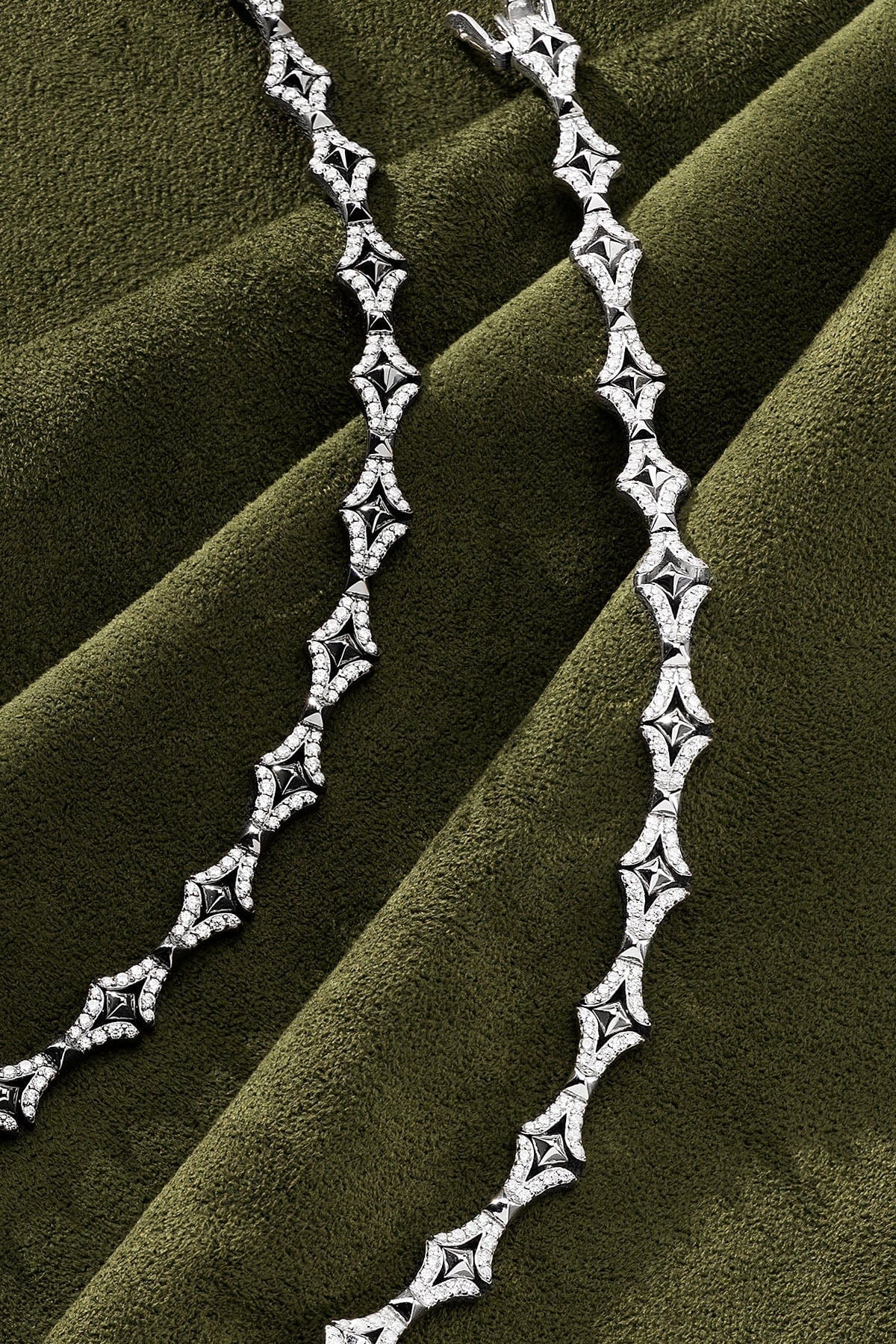 Silver bracelet on a green fabric background