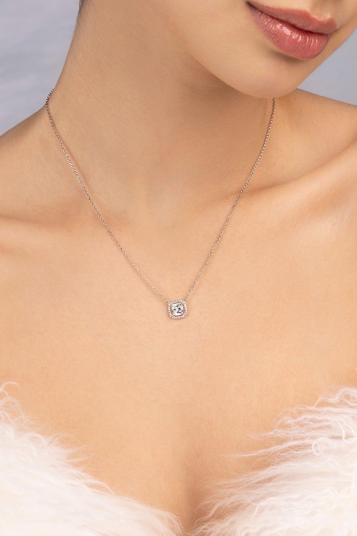 Model wearing APM MONACO adjustable necklace with small square stone design