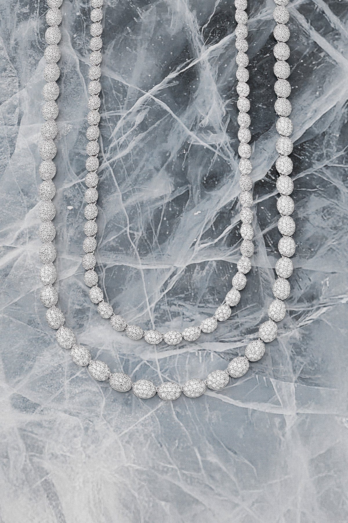 Set of silver beaded necklaces on a marble surface