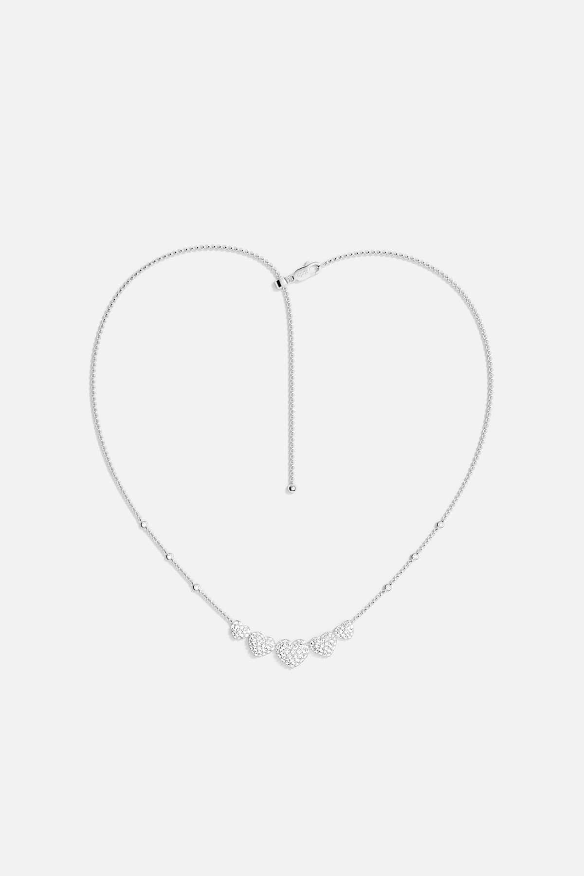 APM MONACO silver necklace with five heart-shaped pendants design on a white background