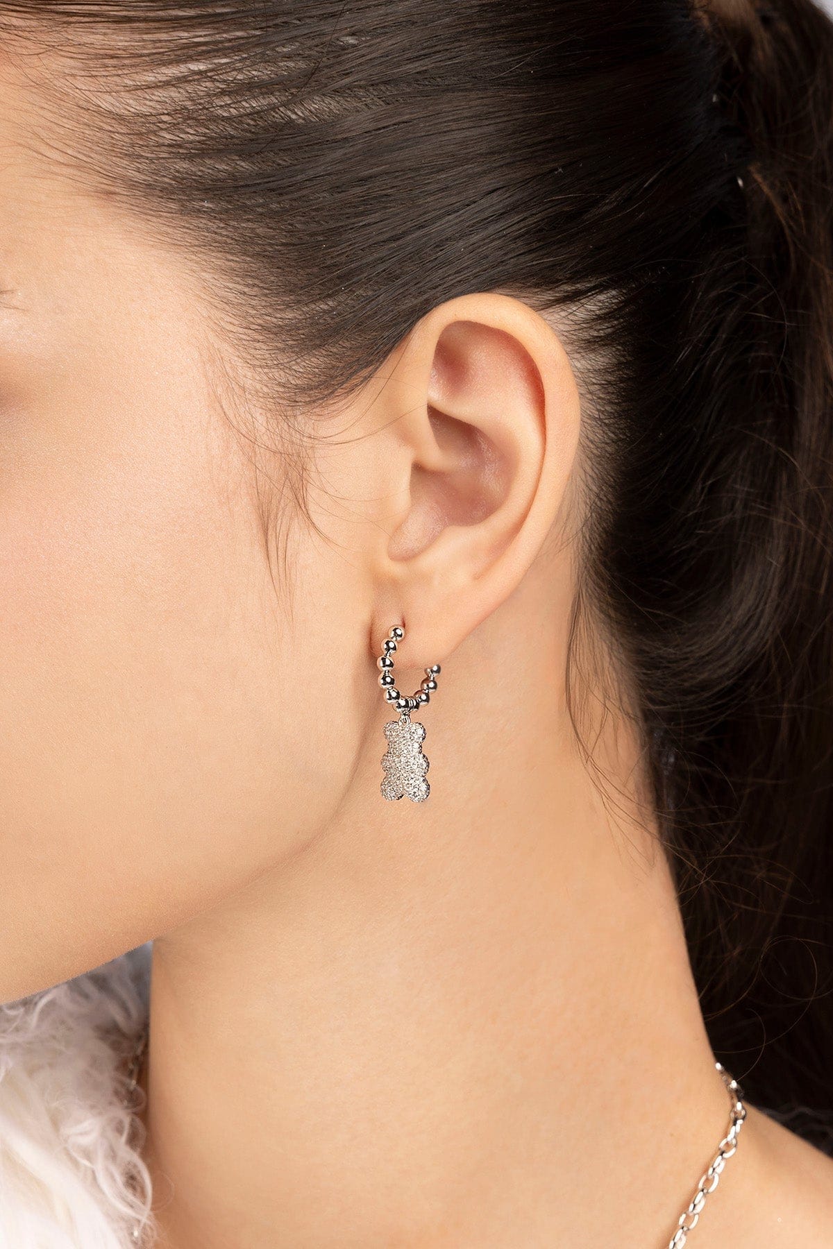 Close-up of an ear wearing a silver earring  with baby yummy bear hoop design worn on model 