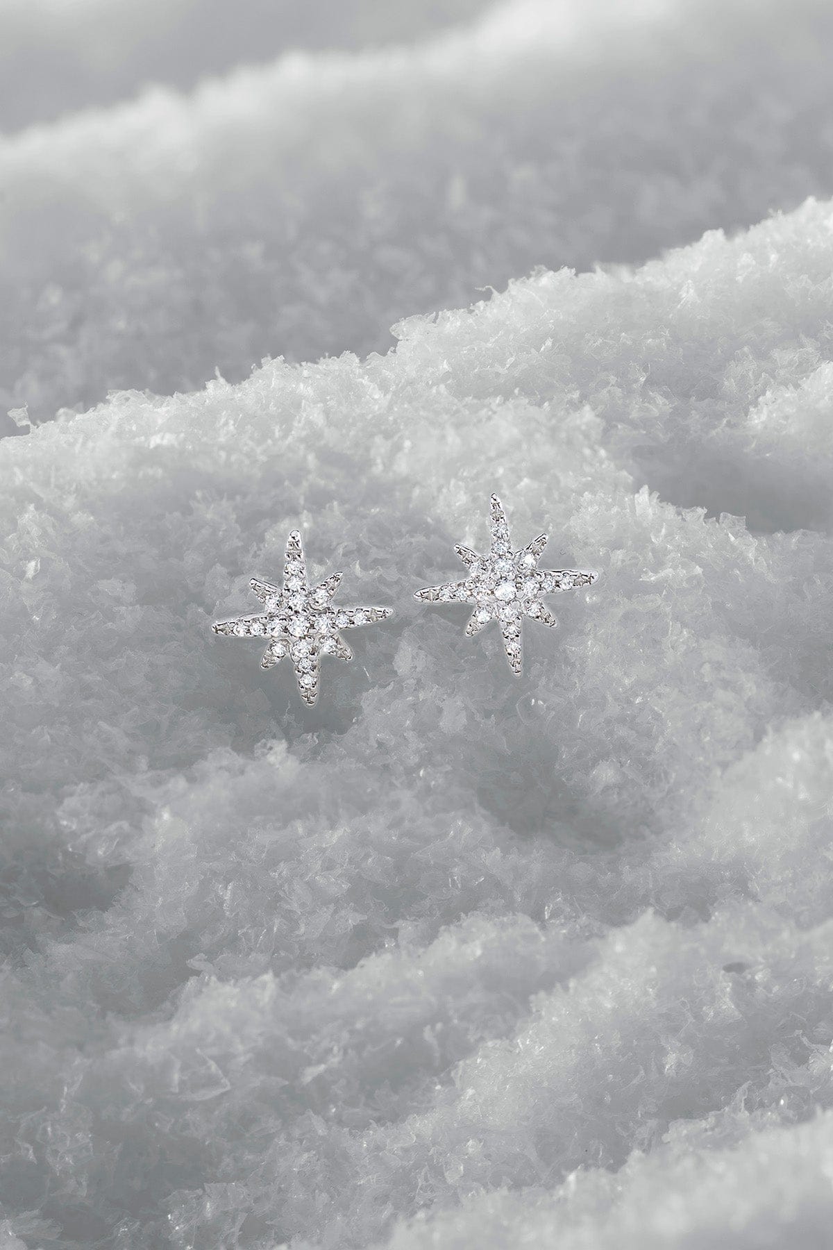 Star-shaped earrings on a snowy background