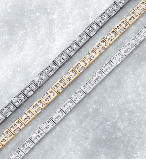 Three APM MONACO hiver bracelets in gold, silver, and white gold on a light gray background