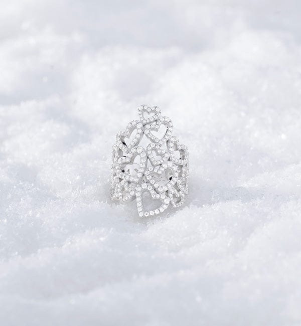 APM MONACO silver heart-shaped ring on a textured white surface