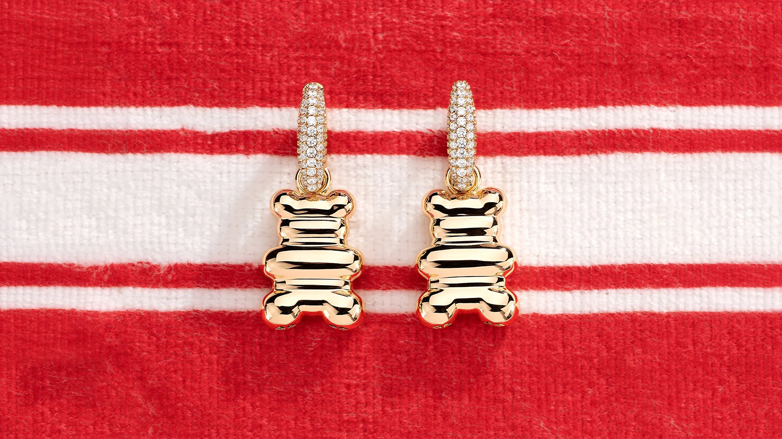 APM MONACO yellow bear-shaped earrings on a red and white striped background