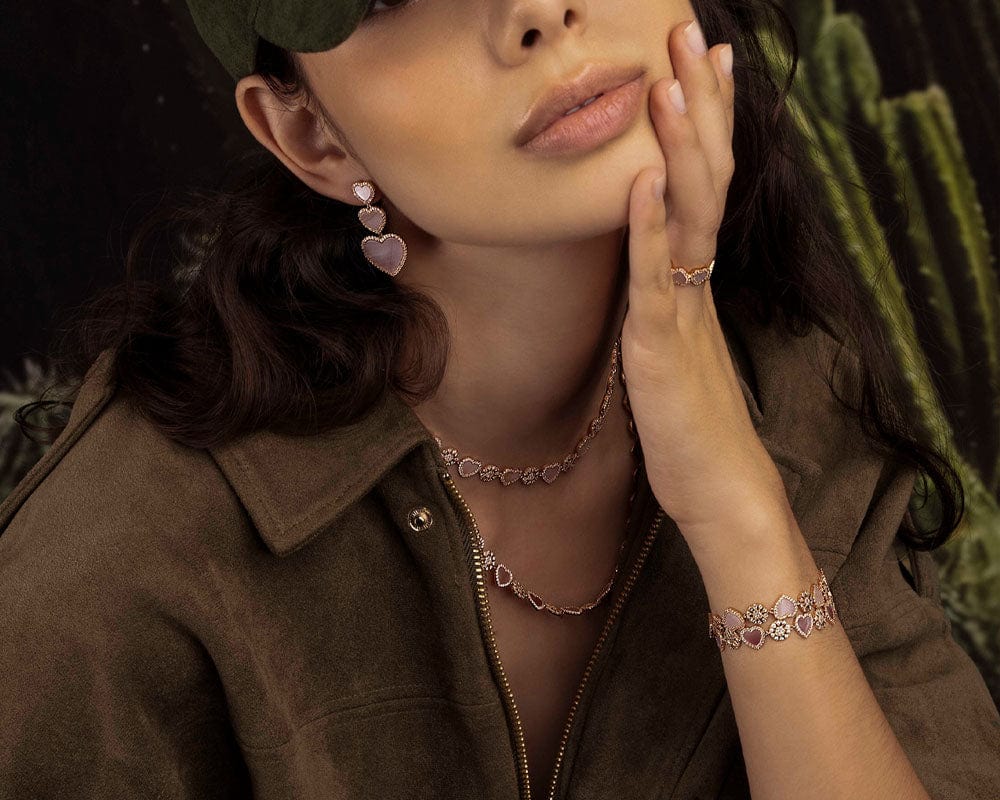 Woman wearing heart-shaped jewelry with a cactus in the background