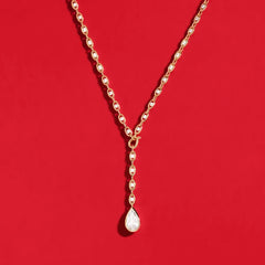 APM Monaco Yellow Soleil Drop necklace on a red background