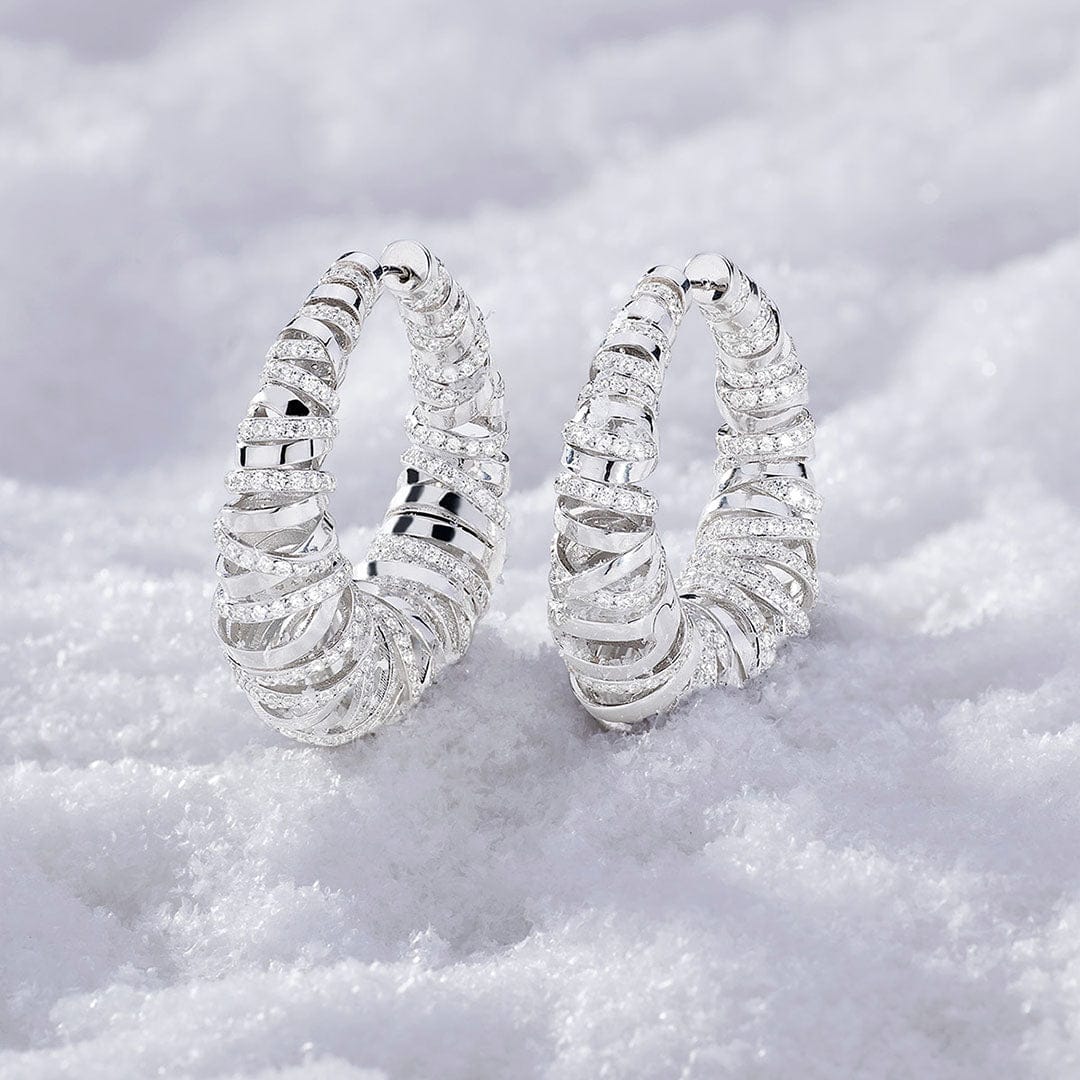 APM MOANCO silver hiver enlace earrings on a textured white surface