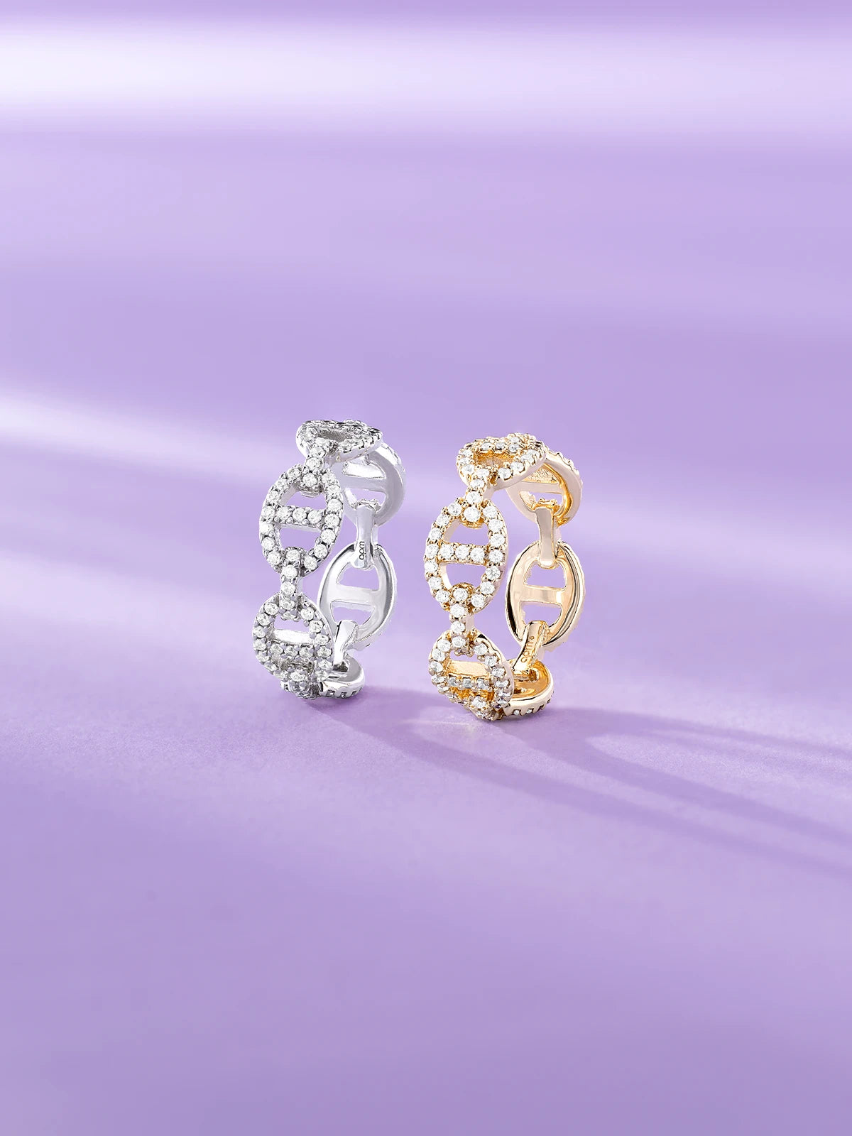 Two APM Yacht Club rings, one silver and one gold, on a purple background